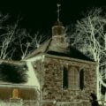 Kaplica widziana nocą. Na ścianie widać cień czarownicy, wiedźmy.