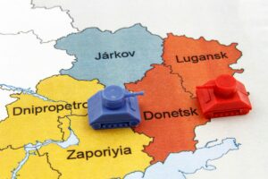 Donbas: mapa Ukrainy z obwodami donieckim i ługańskim oraz dwoma czołgami skierowanymi przeciw sobie