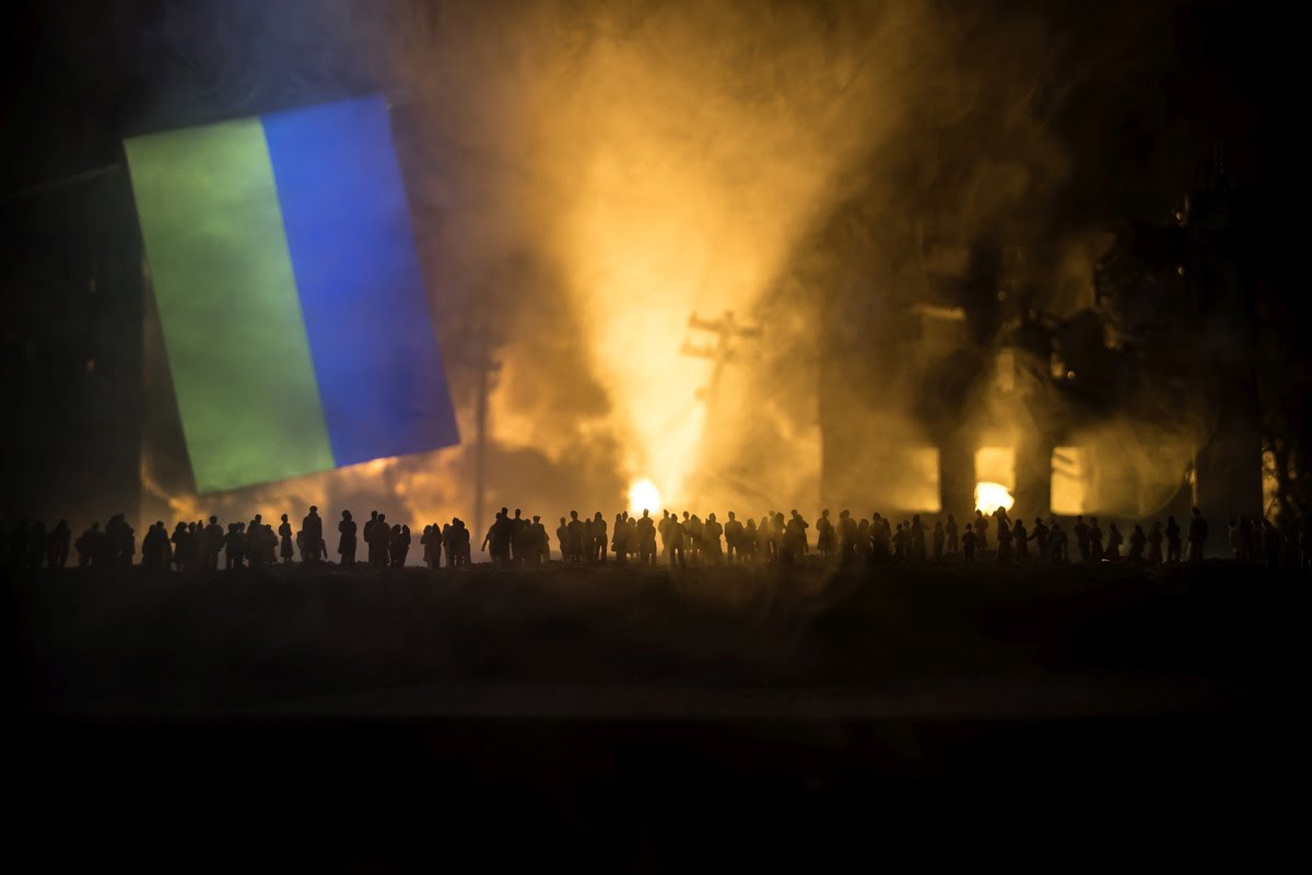 obraz wojny, ludzie na tle płonącego miasta, flaga Ukrainy