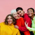 cztery uśmiechnięte dziewczyny w kolorowych ubraniach - ciałopozytywność