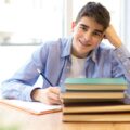 lektury dla ósmoklasistów. nastolatek siedzi przy biurku z książkami